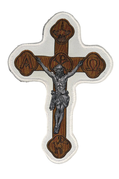 Woven patch with velcro hook backing depicting a brown crucifix.